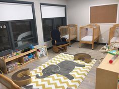 a child's playroom with toys, cribs and other items on the floor