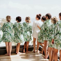 a group of women standing on top of a balcony next to each other wearing green leaf robes