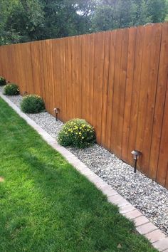 a wooden fence next to a grassy yard