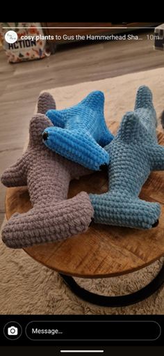 three knitted shoes sitting on top of a wooden table