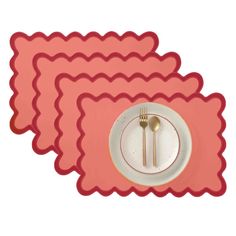 three placemats with forks and spoons on top of each one in pink