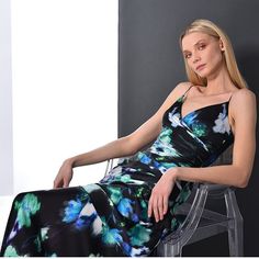 a woman in a black and blue dress sitting on a chair