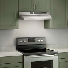 a stove top oven sitting inside of a kitchen next to green cupboards and drawers