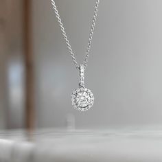 One (1) 18K White gold round diamond halo pendant prong set with (1) 48/100CT center diamond of fine (I) color and (SI1) clarity and (23) round brilliant cut diamond 18/100CTW of fine (G) color and (VS2) clarity. This necklace can be customized to fit your needs. Please give us a call at 314-548-5100 to have your custom order placed. **10K and 18K and larger stone sizes available by request. Sterling Silver Diamond White Necklace With Halo Design, Dazzling Cubic Zirconia Diamond Necklace With Halo Design, Diamond White Halo Diamond Jewelry, Classic Diamond Necklace With Halo Round Cut, Classic Diamond White Necklace With Halo Design, Diamond White Solitaire Necklace With Halo Design, Halo Diamond Jewelry With Round Cut, Brilliant Cut Diamond Pendant Necklace, Classic Diamond White Halo Necklace