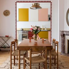 a dining room table and chairs in front of a fireplace