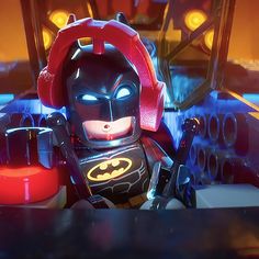 the lego batman movie character is sitting in front of a red light