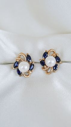 * Earring Material: Sapphire, Pearl, 14K Yellow Gold  * Earring Dimensions:0.5x0.5 Inch,   * Stone Weight & sizes: 8 Blue Sapphire - 1.04ct, Pearl - 6.5-6.7MM  * Earring material: 14k yellow gold, Post Push Back with Jackets   * Overall weight: 3.7g Vintage Pearl, Pearl Earring, Gold Earring, Hyde Park, Vintage Pearls, Yellow Gold Earring, Blue Jacket, Jewelry Earrings Studs, Blue Topaz