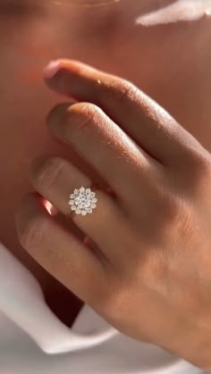 a woman's hand with a diamond ring on it