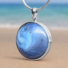 Introducing our exquisite Sterling Silver Leland Blue Locket Pendant, a perfect blend of beauty and elegance! This stunning locket features a genuine 23mm diameter Leland Blue stone set in high-quality Sterling Silver. The captivating foundry glass, born from the short-lived days of smelting by the Lake Superior Iron Company in Leland, Michigan, between 1875 and 1900, carries a unique and vibrant history. Wear this unique pendant close to your heart and embrace the essence of Michigan's geological heritage. Leland Blue, with its striking shades of blue, purple, or green, is a treasured symbol of the state, found along the scenic shores of Lake Michigan and Lake Huron. The locket's craftsmanship showcases the natural beauty of the stone, making it a timeless addition to your jewelry collect Blue Medallion Jewelry With Polished Finish, Blue Jewelry With Large Pendant For Formal Occasions, Formal Blue Jewelry With Large Pendant, Formal Blue Locket Jewelry, Blue Round Sterling Silver Jewelry, Blue Round Gemstone Jewelry, Handmade Blue Jewelry With Round Stone, Blue Jewelry With Detachable Round Pendant, Elegant Blue Cabochon Jewelry