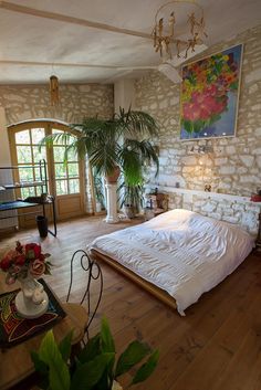 a bedroom with a large bed and potted plants