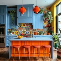 a kitchen with blue cabinets and orange stools in front of an island countertop