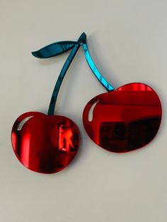 two red heart shaped sunglasses with a blue ribbon on the top and one in the middle