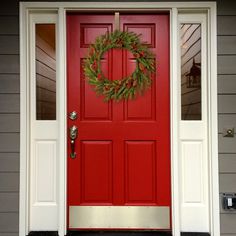 a red front door with a wreath on it