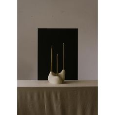 three white vases sitting on top of a table