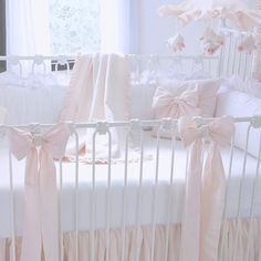 a white crib with pink bows on it