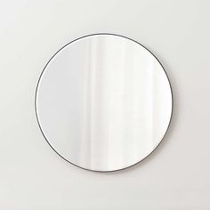 a round mirror sitting on top of a white wall