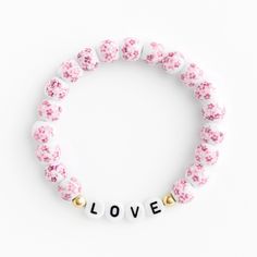 Elegant Pink Stretch Bracelet For Everyday, Casual Rose Gold Jewelry For Gift, Everyday Pink Hypoallergenic Stretch Bracelet, Adjustable White Beaded Feminine Bracelets, Pink Flower Jewelry With Letter Beads, Pink Flower Jewelry For Everyday, White Feminine Beaded Bracelets, Feminine White Bracelets For Gifts, Feminine White Round Beaded Bracelets