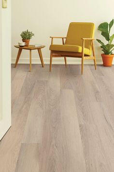 a living room scene with focus on the wood flooring and chair next to it