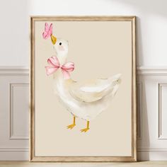 a white duck with a pink bow on it's head in front of a beige wall