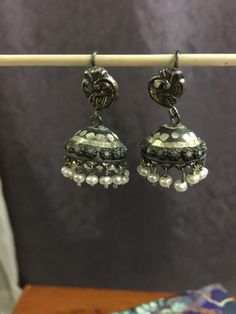 "I have accented a pair of unique Jhumkas with freshwater pearls. These are super cute with a bit of etched work on them. The Peacock ear wires add more drama. These are light weight and won't pull on your ears. If you are new to Jhumkas I would highly recommend this pair. You will love this pair. Pair it with any outfit you can dream of to your favorite Indian Restaurant.    TOTAL Length - 1.25\". Please feel free to ask me for more pictures or questions. Thank You for Shopping Jhumkas they are Ancient, Elegant, Opulent and Regal!l" Silver Kundan Jhumkas With Pearl Drop, Traditional Festive Jhumkas With Peacock Design, Traditional Peacock Design Jhumkas For Festive Occasions, Elegant Navratri Jhumkas, Festive Peacock Design Jhumkas For Celebration, Festive Celebration Jhumkas With Peacock Design, Silver Danglers With Pearl Drop For Wedding, Silver Chandbali Pearl Drop Danglers, Silver Pearl Earrings With Latkans