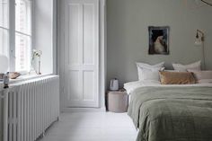 a bed sitting next to a white radiator in a bedroom