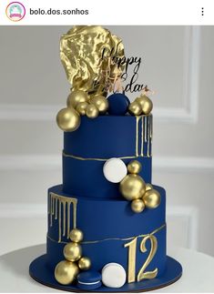 a blue cake with gold decorations on top