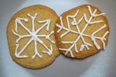 two cookies with white icing are on a plate