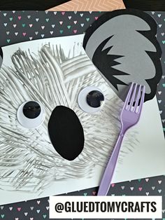 a paper cut out of a koala bear with a fork in it's mouth