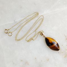 "You can choose your own gem in my store. Let me know if you would like to see options Gemstone: Brown YellowTiger Eye Gold Purity : Guaranteed 14kt pure GOLD Gem weight 9.60 carats Gem shape: Marquis Cabachon shape Gold weight: 0.56 grame Total weight: 2.48 grame The Gemstone in this pendant is ethically sourced and is exploitation free. Brown Yellow Tiger Eye is a beautiful Gemstone of patterns like no other Gemstone. Please note that the pendant is made with absolutely pure 14kt Gold. Pendant 14k Gold Gemstones With Bezel Setting For Gift, 14k Yellow Gold Gemstones For Gift, Yellow Gold Cabochon Teardrop Pendant Necklace, Teardrop Bezel Set Necklace Gift, Teardrop Pendant Jewelry With Bezel Setting, Gift Jewelry With Bezel Setting In Teardrop Pendant Shape, 14k Gold Cabochon Jewelry As Gift, Gift Jewelry Teardrop Pendant With Bezel Setting, Gift Teardrop Pendant Jewelry With Bezel Setting