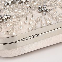 Searching for the perfect accessory to elevate your wedding dress or evening attire? The Crystal Elegance Pearl Beaded Clutch is a stunning choice that exudes romantic sophistication and poetic charm. An elegant statement clutch featuring a delicate beaded design with white pearls and crystals, complemented by silver hardware and a smooth satin back. Its crisp, feminine style makes it a standout piece for any big days and special occasion. Why We Love It... We adore the intricate beaded floral d Elegant Pearl White Clutch For Events, Elegant Pearl White Clutch Evening Bag, Elegant Pearl White Party Clutch, Elegant Pearl White Evening Bag, Luxury Pearl Clutch For Events, Elegant Embellished Evening Bag, Silver Pearl-embellished Clutch For Evening, Elegant Pearl White Clutch With Pearl Handle, Elegant Pearl White Clutch With Pearl Embroidery