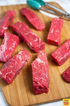 raw meat is cut up on a cutting board and ready to be cooked in the oven