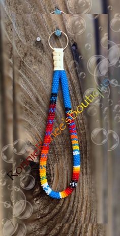 a colorful beaded keychain hanging from a tree