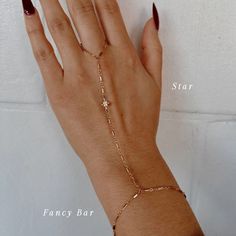 The Slayer Girl Hand Chain is the perfect customized hand chain that gives off the ultimate sparkle. Add a charm to your hand chain to create a piece that is custom made for YOU just like you're in our store in Scottsdale, AZ! Product Details: Made to Order - FINAL SALE 14K Gold-Filled Starburst, Rope or Fancy Bar chain Gothic Initials, Birthstones, CZ Star, Flower & Roman Cross Charms Available 6", 7", 8" Wrist Sizes Available 3" Ring Circumference with 3.5" Connecting Chain Water-Wearable Made Aesthetic Hand Jewelry, Permanent Hand Chain, Hand Chain Aesthetic, Hand Chain Jewelry Gold, Fancy Bar, Chains Aesthetic, Hand Chain Jewelry, Finger Bracelets, Gold Bracelet Simple