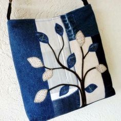 a blue and white bag hanging on the wall with a tree design painted on it