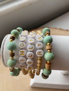 Our 5 stack MINT-TO-BE boho stack! These are super stylish, comfortable and perfect for daily wear! Such a chic boho-look! (These are meant to fit snug. If you would like them to feel loose and move around on your wrist, please size up). Each bracelet is carefully handmade with high quality materials: -8mm natural wood beads (mint color) -4mm natural wood beads -natural wood heishi beads -3mm gold hematite beads -7mm white/gold acrylic letters (other color options available- see pic) -Cord: high Everyday Personalized Bohemian Friendship Bracelets, Adjustable Green Beaded Bracelets For Personalized Gift, Adjustable Green Beaded Bracelets For Gifts, Everyday Bohemian Personalized Beaded Bracelets, Everyday Personalized Bohemian Bracelets, Bohemian Personalized Green Bracelets, Personalized Green Bohemian Bracelets, Green Wooden Beaded Bracelets As Gift, Personalized Green Beaded Bracelets With Letter Beads