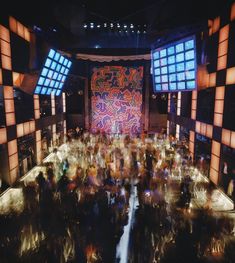 a large group of people standing in front of a stage with lots of lights on it