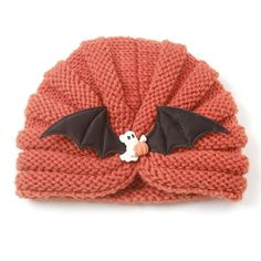 a knitted hat with a bat on the front and a small stuffed animal in the middle