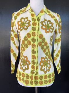 1960s Alex Colman blouse. White, orange, green and yellow rayon. Dry clean or hand wash. Five button front. Measurements  34" bust 30" midriff 34" hem 25" length 21" sleeves 13" shoulders Lovely blouse shows well.  A pattern printing irregularity is noted on the back as shown in pics. Green Retro Print Shirt For Spring, Fitted Yellow Printed Shirt, Vintage Orange Blouse For Summer, Vintage Orange Summer Blouse, Retro Green Tops For Fall, Fitted Green Tops With Retro Print, Fitted Green Top With Retro Print, Green Fitted Printed Shirt, Vintage Fitted Green Tops