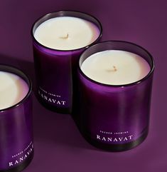 three candles sitting next to each other on a purple surface with the words kannavat written in white