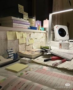 a cluttered desk with papers and a computer monitor on it's side, in front of a mirror