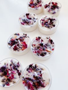 six small bowls filled with different types of food on top of a white tablecloth