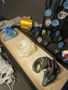 some glass beads and other items on a wooden board with string attached to the sides