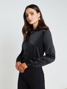 A quintessential blouse in a lustrous silk charmeuse and true black hue. Classic look has a soft, liquid hand and tailored silhouette shaped by sharp sartorial details like a stand collar, long button-cuff sleeves, and back yoke with inverted pleat. An open neckline and curved hem add subtle femininity. A nimble style that works equally well with jeans or skirts. Fastens in front with tonal buttons. | L'AGENCE Tyler Silk Blouse Top In Black Collarless Leather Jacket, Black Silk Top, Denim Blouse, Silk Charmeuse, Silk Top, Cuff Sleeves, Black Silk, Blouse Top, What I Wore