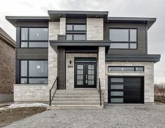 a large house with two garages and stone steps leading up to the front door