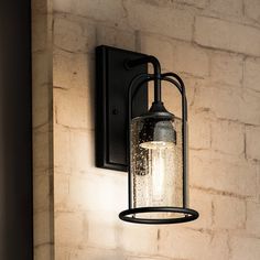 a light that is on the side of a brick wall next to a lamp fixture