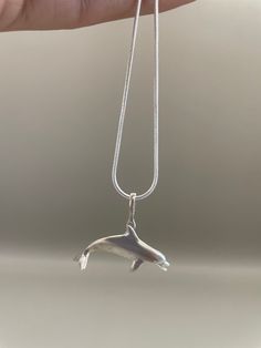 A unique, eye-catching addition to any jewelry collection, this 925 sterling silver dolphin necklace is crafted with meticulous detail and will surely be admired. The beautiful design will last for years to come. This pendant is included with a black waxed cord necklace(18inch). **Note: Pictures are enlarged to show detail. All pendants are packaged and shipped in a cotton baggy inside a water and tear-resistant bubble wrap envelope. If you have any questions about this item or any other items listed in our shop please do not hesitate to contact us.** Made out of .925 Sterling Silver. Completely solid. Not too light or heavy. Recommend for adults and teens. Made in USA Copyright belonging to Lluch Art Design. Dolphin Necklace, Necklace Craft, Ocean Animals, Cord Necklace, Dolphins, Gifts For Women, Jewelry Gifts, Jewelry Collection, Jewelry Necklace Pendant