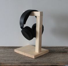 a pair of headphones sitting on top of a wooden stand