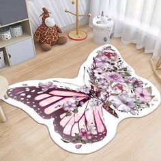 a pink butterfly shaped rug with flowers on it