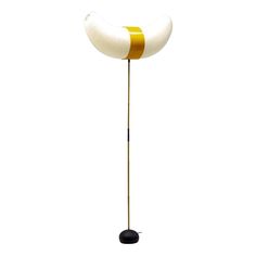 a white and yellow floor lamp with a black base