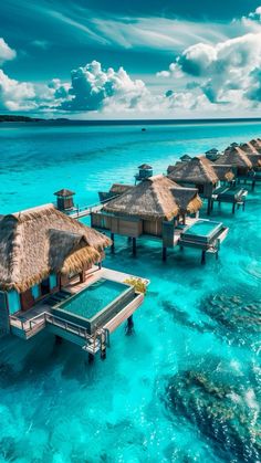 the water is crystal blue and clear with some huts on it's sides in the ocean